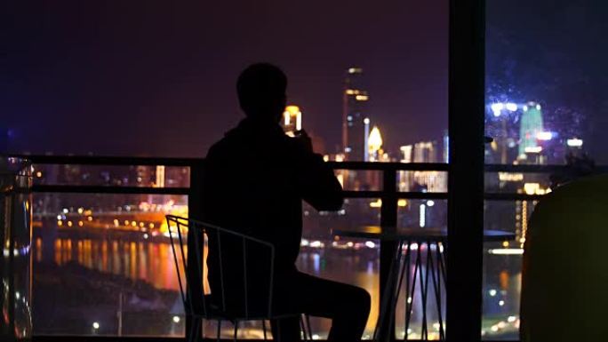 男人坐着看着城市之夜