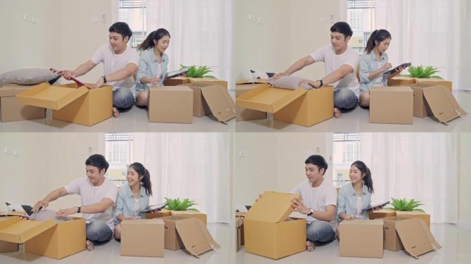 4k分辨率年轻的亚洲夫妇在搬家日检查和包装箱进入新家。搬迁概念