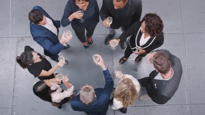 在现代办公室用香槟吐司庆祝成功的商业团队的头顶镜头