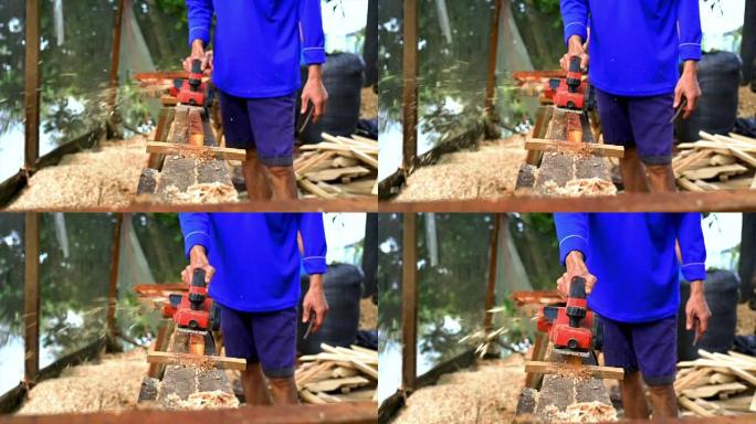 越南东塔丁延的亚洲工人用规划机刨削木材的4k慢动作镜头，木工工具和机器概念