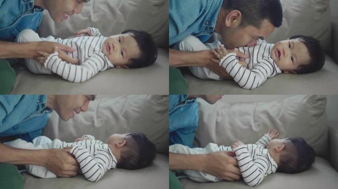 亚洲父亲亲吻婴儿的肚子。