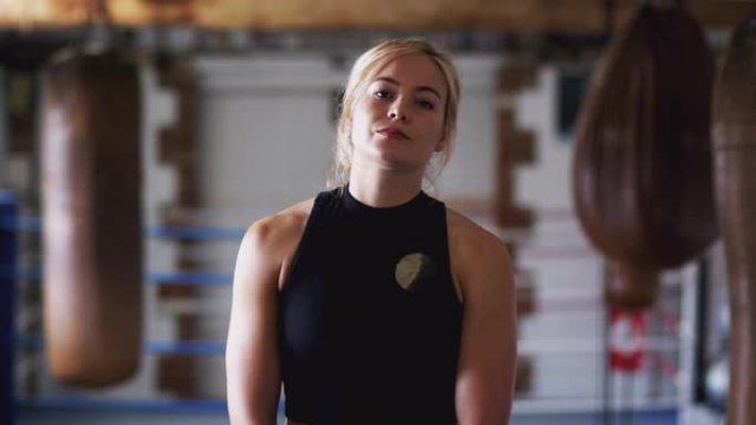 老式沙袋在健身房训练中的女拳击手肖像
