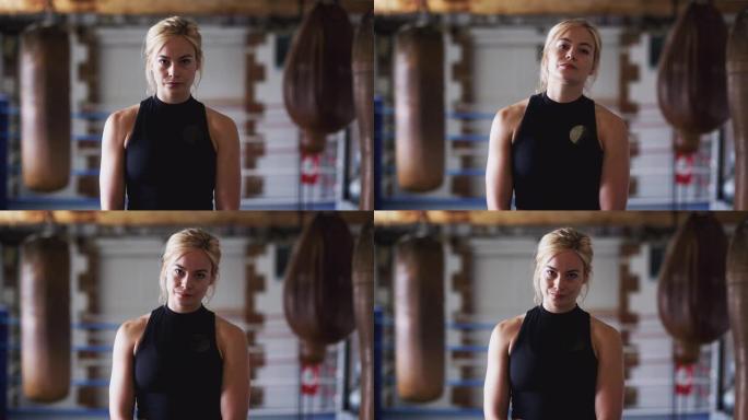 老式沙袋在健身房训练中的女拳击手肖像