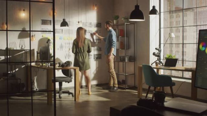 年轻的有创造力的男性和女性正在他们凉爽的办公室阁楼的墙上组织一个故事板。图片代表未来的运动视频。同事