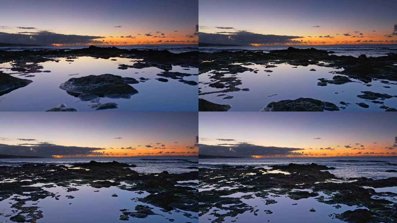 日落天空反射在岩石海洋海岸游泳池。特内里费岛希达尔戈角附近的海滩。万向节射击，4K
