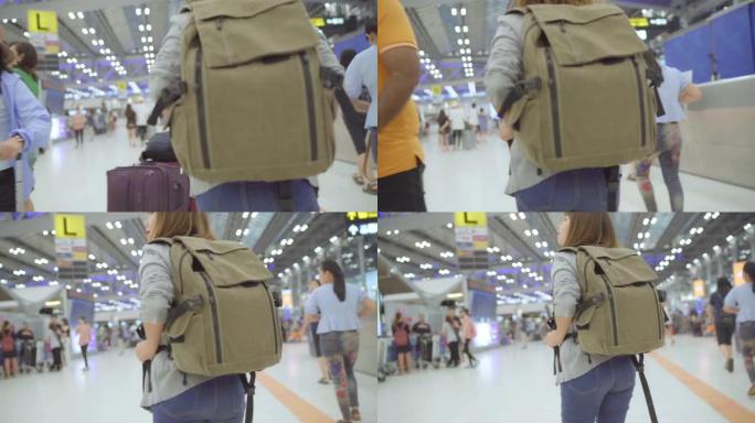 慢动作 -- 年轻的亚洲背包客女子在国际机场散步。
