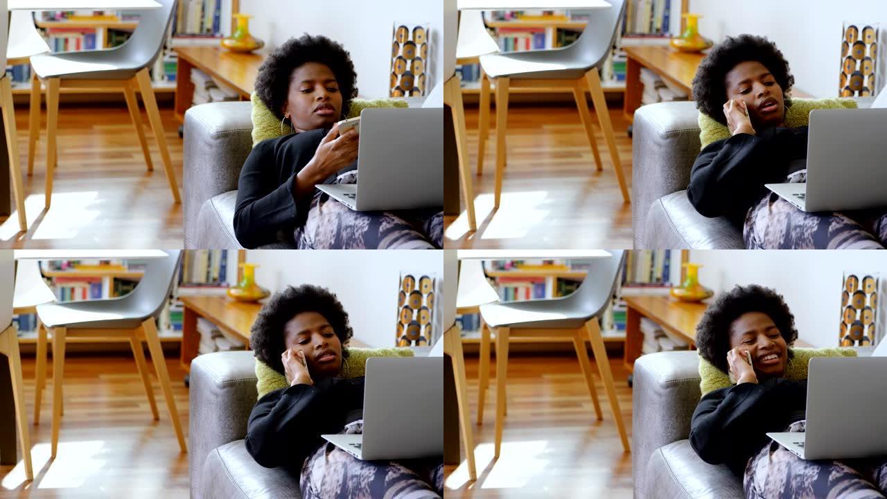 女人在家沙发上使用笔记本电脑时在手机上聊天4k