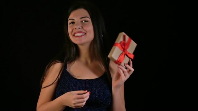 圣诞快乐微笑的年轻女子手里拿着礼品盒。慢动作。