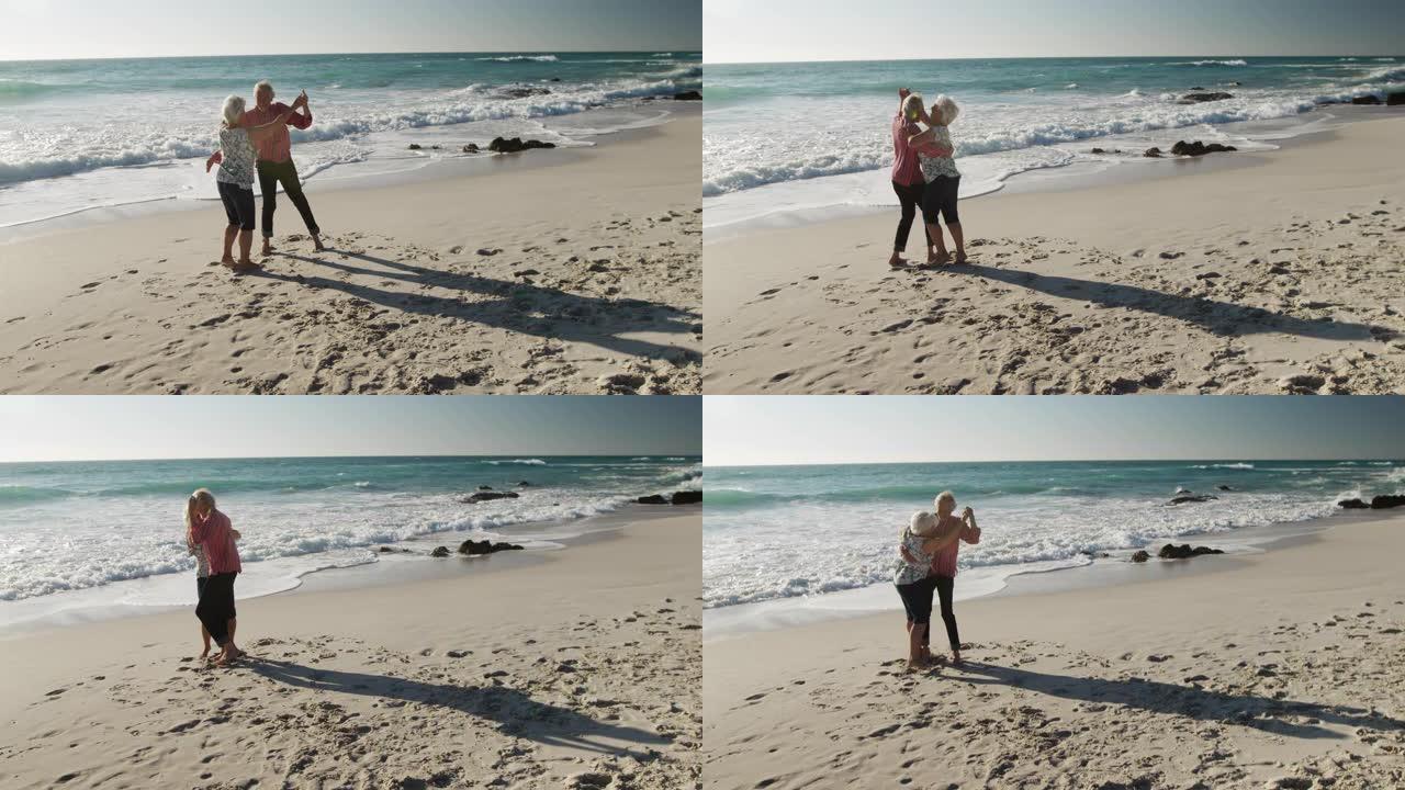高级夫妇在海滩上一起跳舞