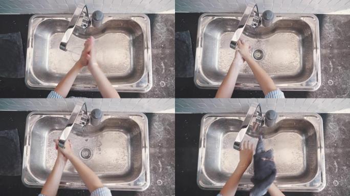女人用水和肥皂洗手的俯视图