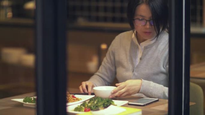 美丽的中国女人在餐馆吃饭