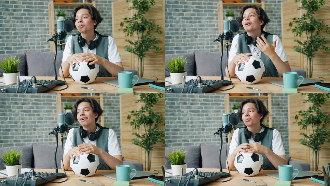 快乐的少年在录音棚里拿着足球用麦克风说话