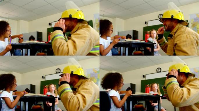 年轻的白人男性消防员在教室4k教女学生消防安全
