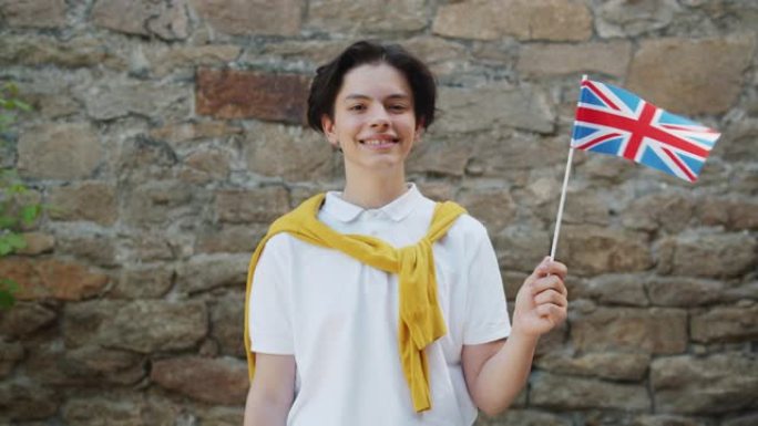 骄傲的英国公民少年与英国国旗在户外微笑的肖像