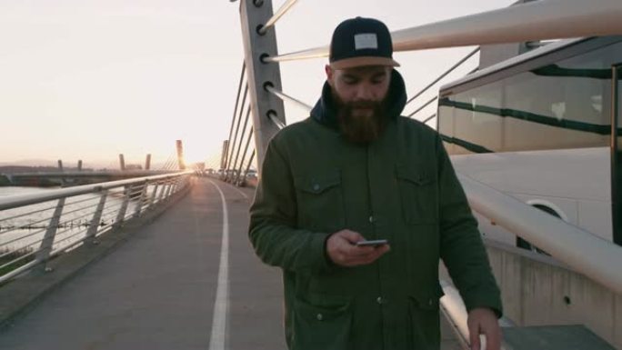 MS Man with smart phone walking on bridge