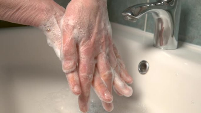 特写: 男人正在洗手，以避免被电晕病毒感染。