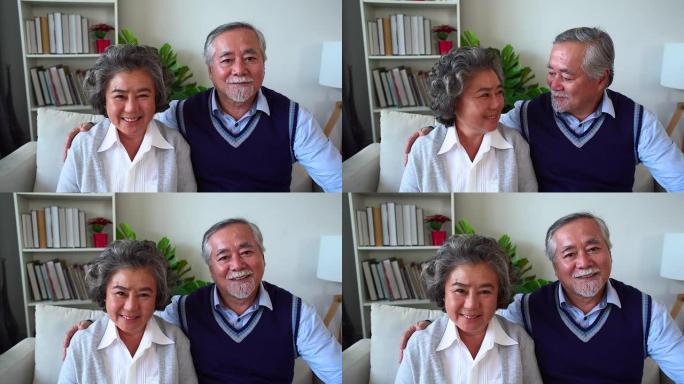 快乐的亚洲老年夫妇享受生活。浪漫的高级夫妇坐在家里的沙发上笑。