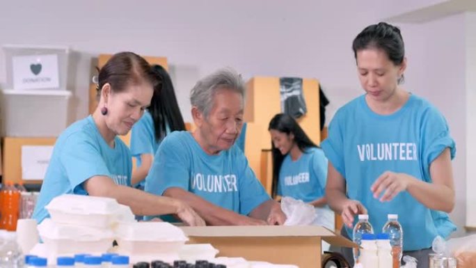 亚洲祖母年龄70岁的志愿者准备免费送餐，而小组朋友为危机冠状病毒COVID-19.Volunteer
