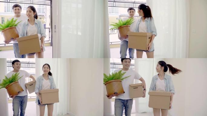 4k解决方案年轻的亚洲夫妇在搬家日携带箱子进入新家。搬迁概念