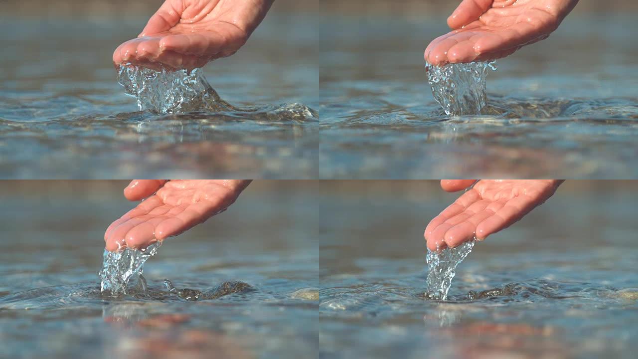 慢动作: 闪闪发光的河水从无法辨认的女孩手掌中流出。