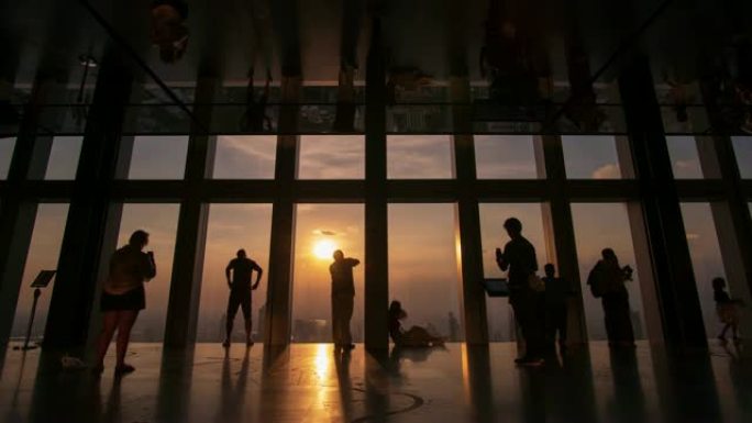 时间流逝和锁定: 游客在日落时间走在摩天大楼的视点上。