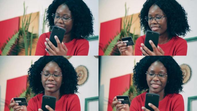 非洲女士正在将卡片数据输入手机并微笑