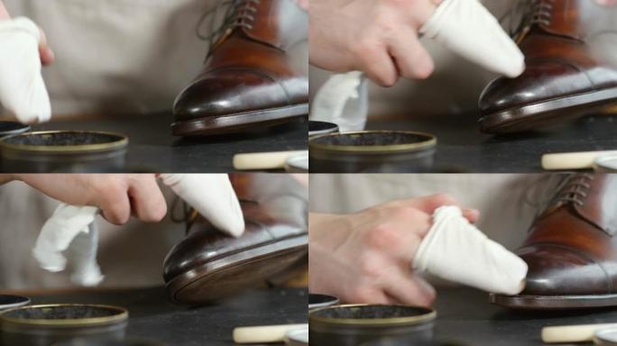 鞋匠用布抛光皮靴的手的特写