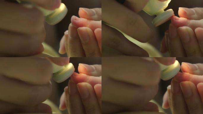 母亲在家里给婴儿剪指甲的特写镜头