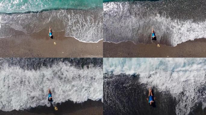 海边，一位女士在海浪中晒日光浴。暑假概念。