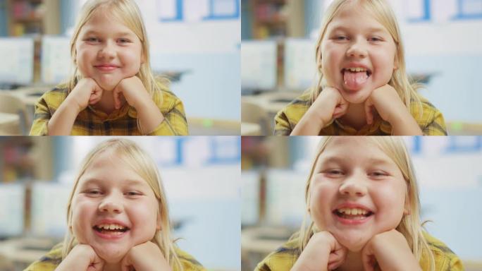 一个可爱的金发小女孩的肖像坐在她的课桌前，开心地微笑着，嘲弄着舌头。聪明的小女孩，微笑着坐在教室里。
