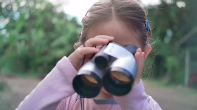 SLO MO可爱快乐儿童女孩使用双筒望远镜