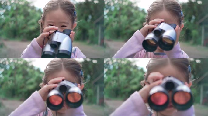 SLO MO可爱快乐儿童女孩使用双筒望远镜