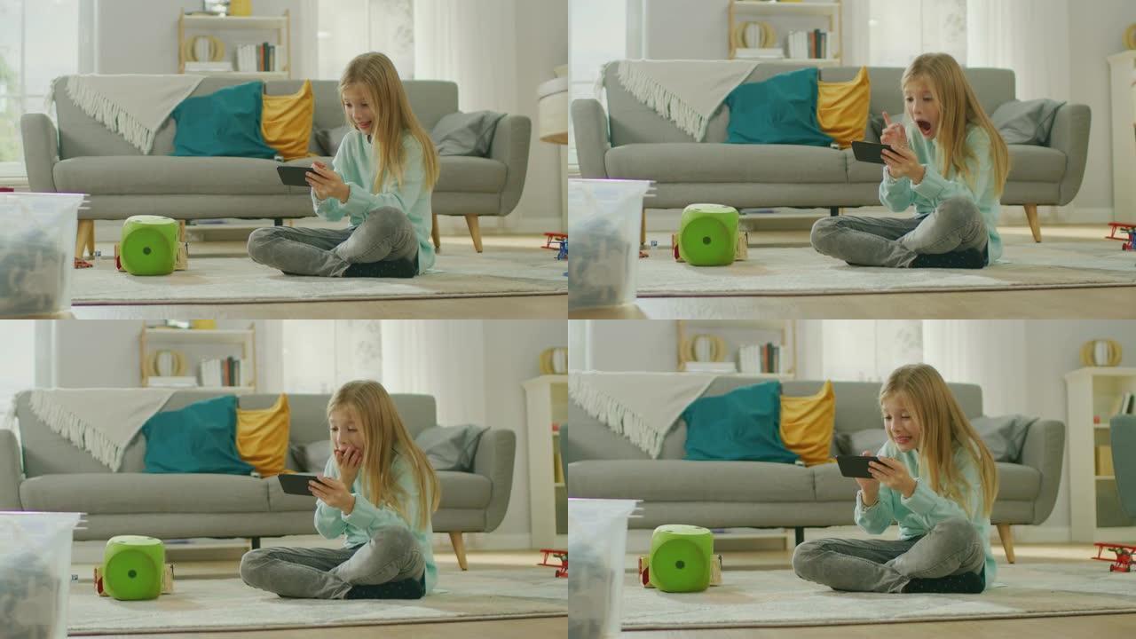 聪明可爱的女孩坐在地毯上玩智能手机上的视频游戏，在水平景观模式下拿着和使用手机。孩子在阳光明媚的客厅
