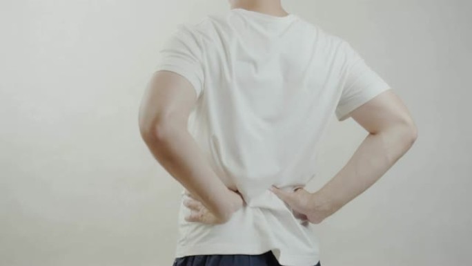 穿着白衬衫的亚洲男子感到腰痛。肌肉疼痛，保健概念。