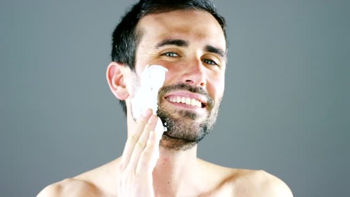 一幅美丽的男人肖像，剃须前使用剃须泡沫，更好地完美剃须，保护你的皮肤免受刺激。