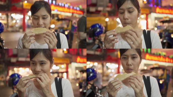 街头美食 -- 泰国曼谷姚瓦拉特路吃脆皮煎饼的年轻女子