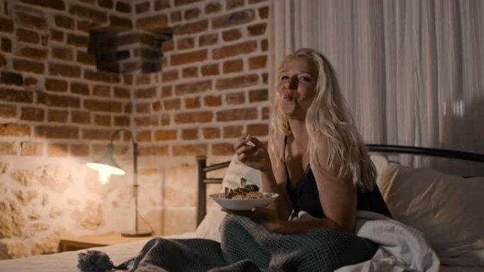 一个女人在床上吃意大利面条的肖像