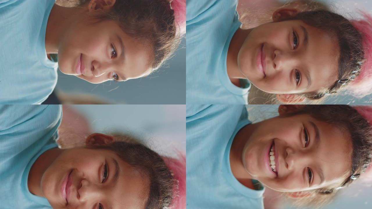 棕色头发的可爱女孩的肖像，一边看着相机一边笑。垂直屏幕方向9:23的视频素材