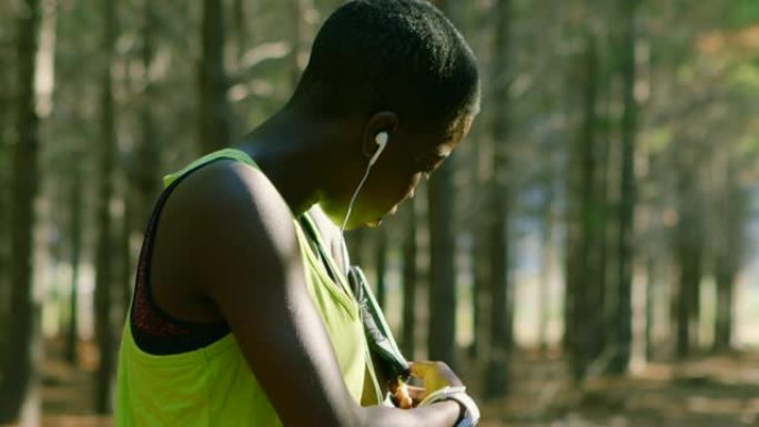 女性慢跑者在森林中调节臂带4k