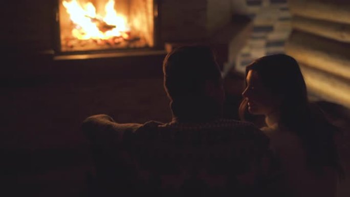 幸福的夫妇坐在壁炉附近的地板上