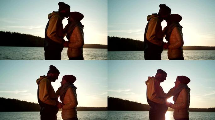 一对拥抱在湖码头上的夫妇。浪漫的日落