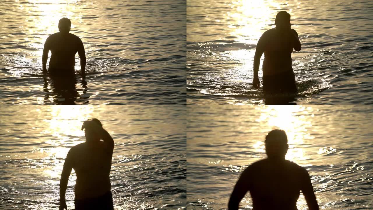 剪影-男人从大海上走，背景是金色的大海