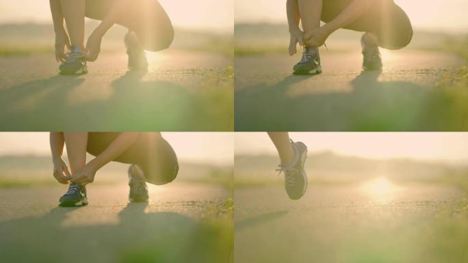 SLO MO无法识别的女人在慢跑时系鞋带