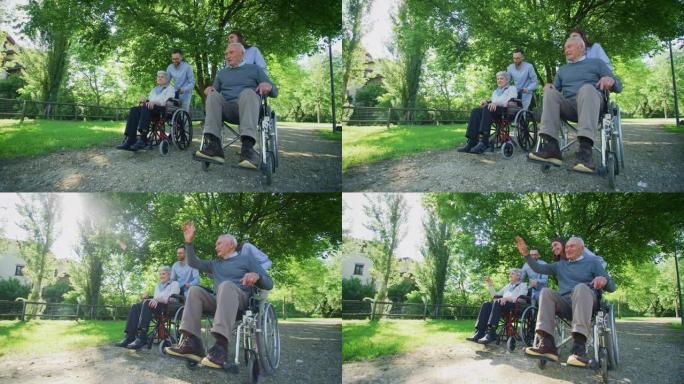 无忧无虑快乐的孙子和他们坐在轮椅上的祖父母的慢动作在阳光明媚的日子里在绿色公园跑步很开心