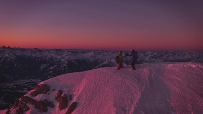 徒步旅行者在白雪皑皑的山峰上握手