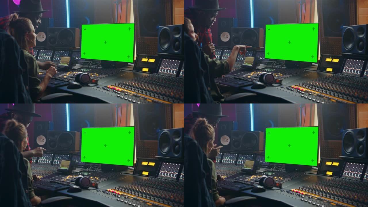 制作人和音频工程师在音乐唱片工作室合作制作新专辑，使用绿屏计算机，控制台进行混音和创作热门歌曲。艺术