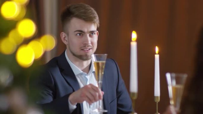 年轻的白人男子在新年与香槟敬酒女友