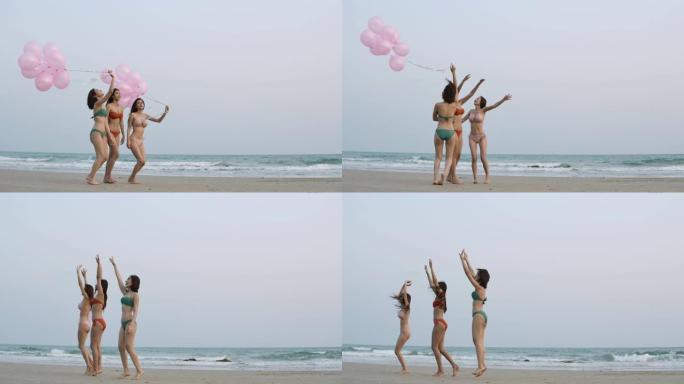 一群快乐的女孩朋友在海滩上，带着快乐的情感拿着五颜六色的气球。有派对庆祝概念的人。4k分辨率。慢动作