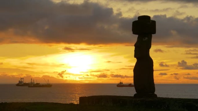 复制空间: 日落时宁静的海洋旁，一座大型摩艾雕像的田园诗般的景色。