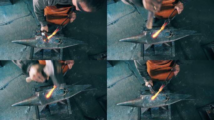 一个铁匠用锤子在铁砧上塑造刀。